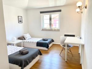 a small bedroom with two beds and a desk at Cascais Terrace Bay Apartment in Cascais