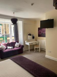 a living room with a purple couch and a table at Crown Hotel in Pateley Bridge