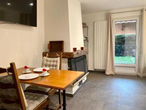 uma sala de jantar com uma mesa e uma lareira em STUDIO CONFORT & DETENTE em Chesières