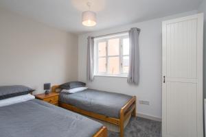 a bedroom with two beds and a window at Rocester Roost in Rocester