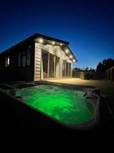 a swimming pool with green liquid in front of a house at Hollicarrs - Dragonfly Lodge in York