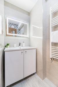bagno bianco con lavandino e doccia di Isaran 2D4E Apartment Brașov a Braşov