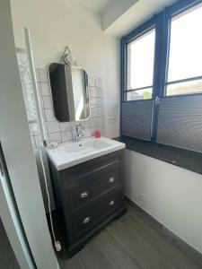 a bathroom with a sink and a tv on the wall at Honey House in Foy-Notre-Dame