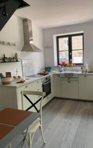 cocina con armarios blancos, fregadero y mesa en Honey House, en Foy-Notre-Dame