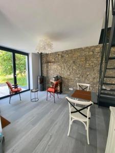 a living room with red chairs and a stone wall at Honey House in Foy-Notre-Dame