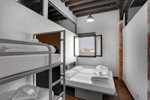 a small room with bunk beds and a window at Generator Venice in Venice