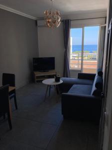 sala de estar con sofá, mesa y ventana en Appartement Bastia Centre en Bastia