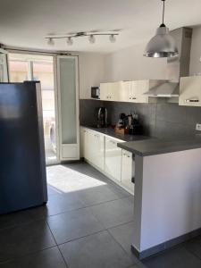 a kitchen with white cabinets and a black counter top at Appartement Bastia Centre in Bastia