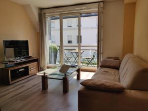 a living room with a couch and a television at Appart'HomeCity - Rouen Lessard in Rouen