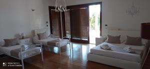 a living room with two beds and chairs and a chandelier at Villetta Del Salento Exclusive B&B in Gallipoli