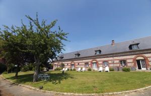 a large brick building with chairs and a tree at Le R'Epi Normand Chambres d'hôtes et Spa in Ourville-en-Caux