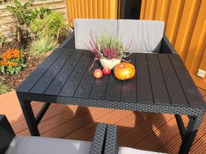 einem schwarzen Tisch mit einem Kürbis und einer Topfpflanze in der Unterkunft Ferienhaus Eldena Greifswald Steffi Fasten in Eldena