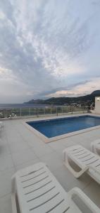 a swimming pool with two lounge chairs on a roof at NUR Apartment in Dobra Voda