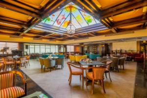 a restaurant with tables and chairs and a stained glass ceiling at Bristol Hotel in Amman