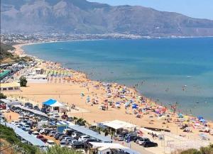 a beach with a lot of people and the water at Villa Giardini in Balestrate
