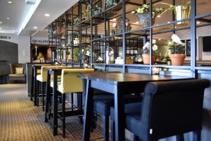 ヨーテボリにあるクオリティ ホテル ウィンのテーブルと椅子、植物のあるレストラン