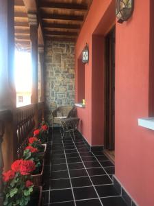 Rales的住宿－LA CASONA DE RALES VILLAVICIOSA，走廊上设有红色的墙壁和花卉,地板上