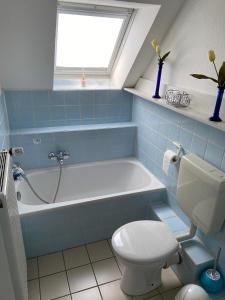 a bathroom with a tub and a toilet and a sink at Haus Windjammer in Friedrichskoog +11 photos