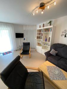 sala de estar con sofá y silla en Haus Windjammer, en Friedrichskoog