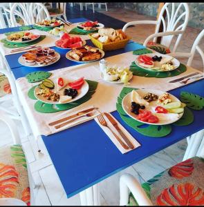 una mesa azul con platos de comida. en Don Kişot Olimpos Hotel, en Olympos