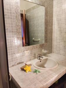 y baño con lavabo y espejo. en Casa di Anna, en San Teodoro
