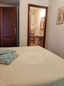 1 dormitorio con 1 cama y baño con lavamanos en Casa di Anna, en San Teodoro