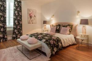 una camera da letto con un grande letto con cuscini rosa di Chez la Tante Louise - appartement privé de charme a Passenans