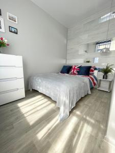 ein Schlafzimmer mit einem Bett und einer weißen Kommode in der Unterkunft Apartment Studio London 51 in Irpin
