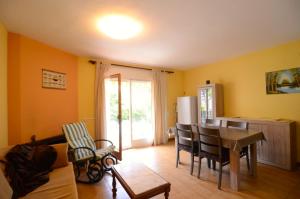 ein Wohnzimmer mit einem Tisch und eine Küche mit gelben Wänden in der Unterkunft Estany I Pb-2 in L'Escala