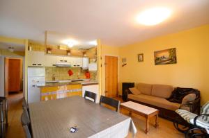 eine Küche und ein Wohnzimmer mit einem Sofa und einem Tisch in der Unterkunft Estany I Pb-2 in L'Escala