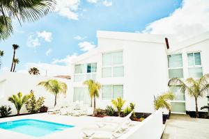 a white house with a swimming pool and lounge chairs at VILA CARLA - 3BDR + 3BATH in Amarilla Golf in San Miguel de Abona