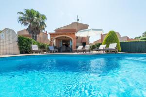 a swimming pool in front of a house at Villas Maribel in Cala Blanca