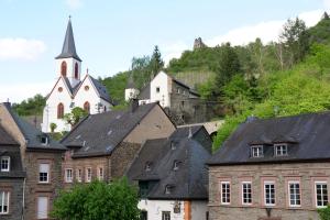 a group of buildings with a church in the background at DTV-zertifizierte Ferienwohnung Kleine Moselruhe - zentral, für 3 Personen, Parkplatz & WLAN in Traben-Trarbach +8 photos