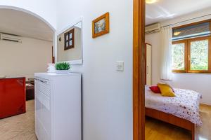 a small bedroom with a bed and a small refrigerator at Apartments Kiki 150 METERS TO THE BEACH in Banjole