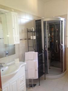 a bathroom with a sink and a shower with towels at Le Sirene Bed and Breakfast in Cellamare