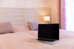 a laptop computer sitting on top of a bed at Villa Elizabeth in Kudowa-Zdrój