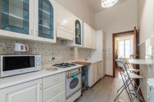 a kitchen with white cabinets and a stove top oven at Termini Central and Elegant Apartment in Rome