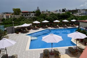 a swimming pool with chairs and umbrellas on a building at Jechrina in Kato Daratso