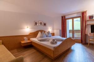 a bedroom with a bed and a large window at Pension-Appartement Mitterhofer in Schenna