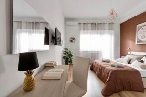 een slaapkamer met een groot bed, een tafel en een bureau bij Homs Sweet Home in Rome