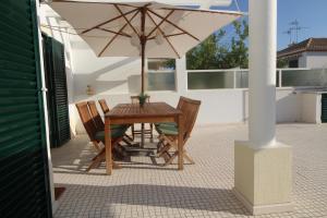een tafel en stoelen onder een parasol op een terras bij Manta Azul in Manta Rota