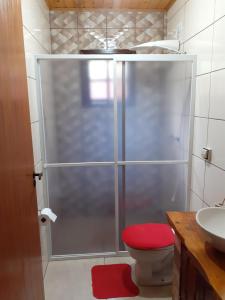 La salle de bains est pourvue d'une douche avec un tabouret rouge. dans l'établissement Chalés Alto da Serra 1, à Campos do Jordão 65 autres photos