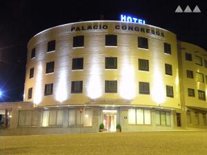 パレンシアにあるHotel Palacio Congresosの夜間の看板が貼られたホテルの建物