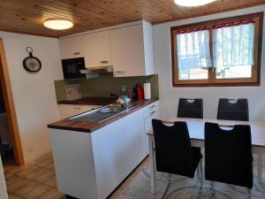 a kitchen with a counter and a table and chairs at Chalet Clair de Lune bei Grächen VS in Gasenried +11 photos