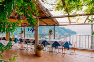 un restaurante con mesas y sillas y vistas al agua en Giuliana's View, en Ravello