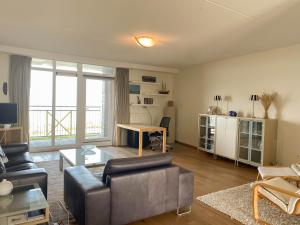 ein Wohnzimmer mit einem Sofa und einem Tisch in der Unterkunft Hello Zeeland - Appartement Port Scaldis 19-012 in Breskens