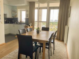 eine Küche und ein Esszimmer mit einem Holztisch und Stühlen in der Unterkunft Hello Zeeland - Appartement Port Scaldis 19-012 in Breskens