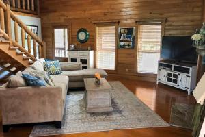 a living room with a couch and a tv at Experience Louisiana, Cabin on Bayou Petite Anse in New Iberia