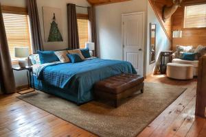 a bedroom with a bed with a blue comforter and a chair at Experience Louisiana, Cabin on Bayou Petite Anse in New Iberia