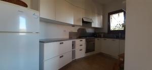 a kitchen with white cabinets and a window at BEACH HOUSE Alice in Cannigione +18 photos
